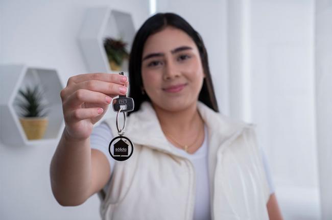 Mujer con su casa propia adquirida con Sólida
